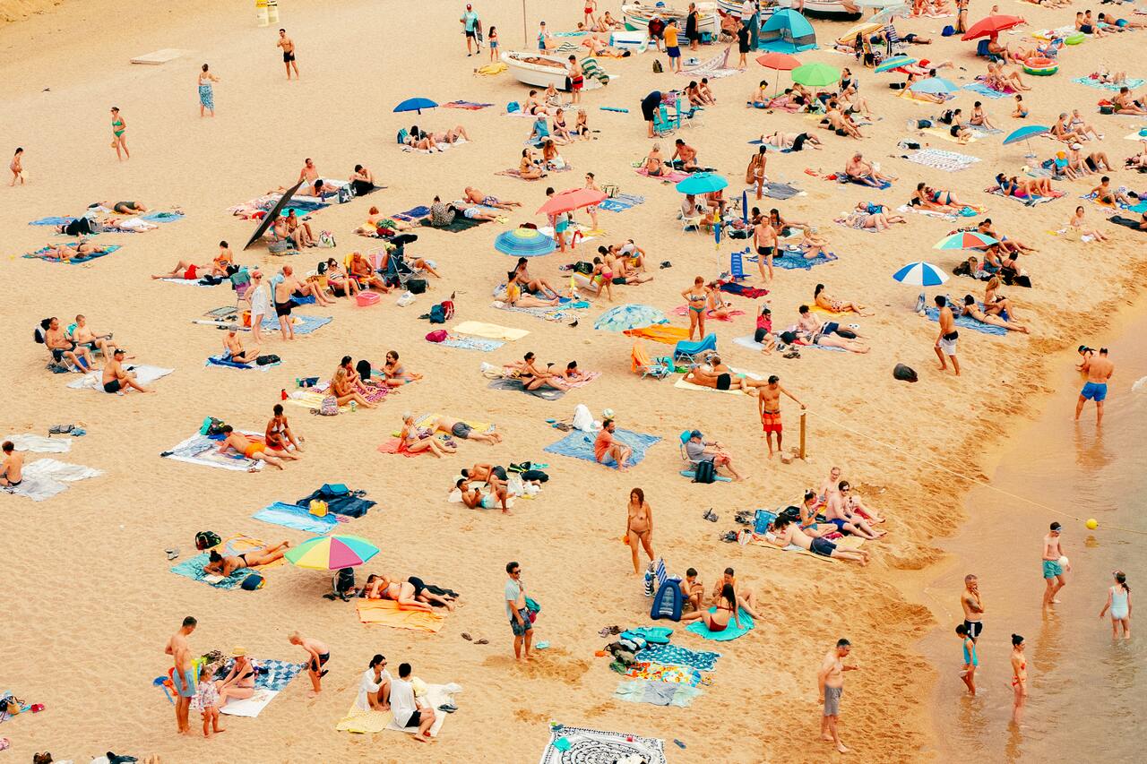  crowded beach with people sunbathing and swimming